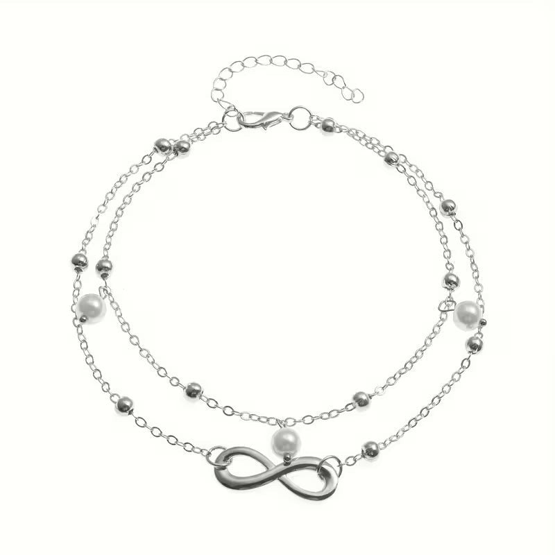 Aramat Jewels dubbel enkelbandje in zilverkleur met infinity symbool en delicate parels voor een zomerse look.
