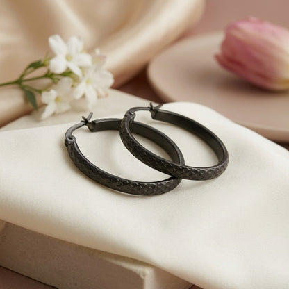Aramat Jewels black stainless steel hoop earrings with a 30mm diameter and a subtle diamond pattern.