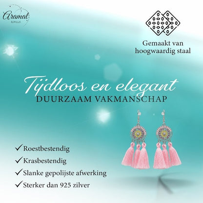 Aramat Jewels boho oorhangers met licht roze kwastjes en roestvrijstalen details voor een zomerse festival look.