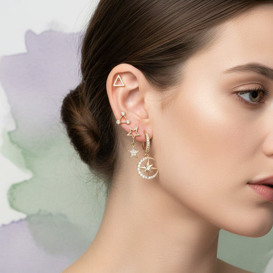 Aramat Jewels set of 6 gold-tone earrings with celestial motifs: stars, moons, and a planet. Some feature cubic zirconia.