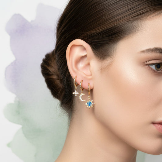 Aramat Jewels set of 6 gold-plated hoop earrings with celestial charms: star, moon, planet, and starburst designs, some with cubic zirconia.
