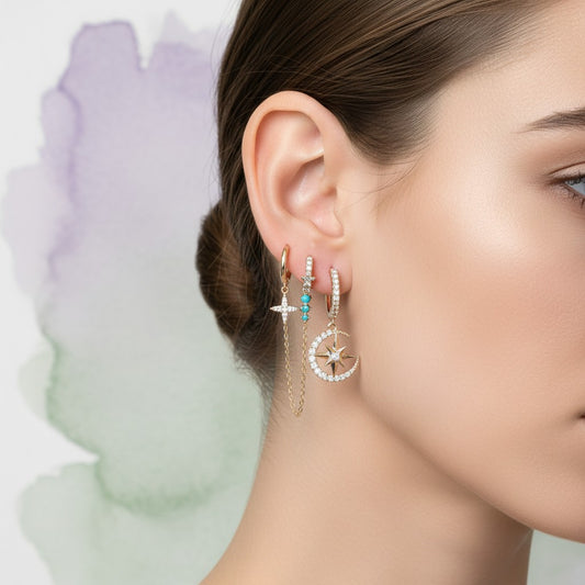 Aramat Jewels Dazzly Ears set of 5 gold-plated hoop earrings with charms: star, chain, turquoise starburst, moon, and pink gem.