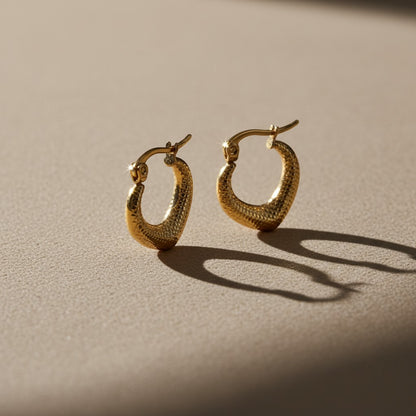Aramat Jewels gold-colored stainless steel drop-shaped hoop earrings with a diamond pattern texture, 20x20mm.