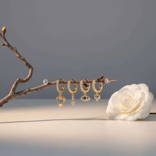 Aramat Jewels gold-plated earring set with silver charms including a rainbow cactus, arrow, evil eye with blue stone, and heart with cubic zirconia.