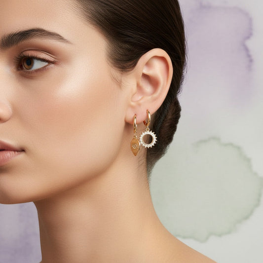 Aramat Jewels set of 6 gold-plated hoop earrings with charms: pearl, evil eye, triangle, sunburst, and teardrop.