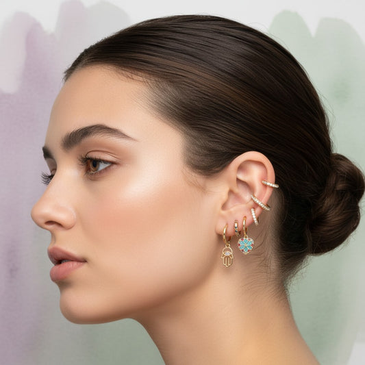 Aramat Jewels gold plated 925 silver earring set with cubic zirconia, including hamsa hand, heart, and ear cuff styles.