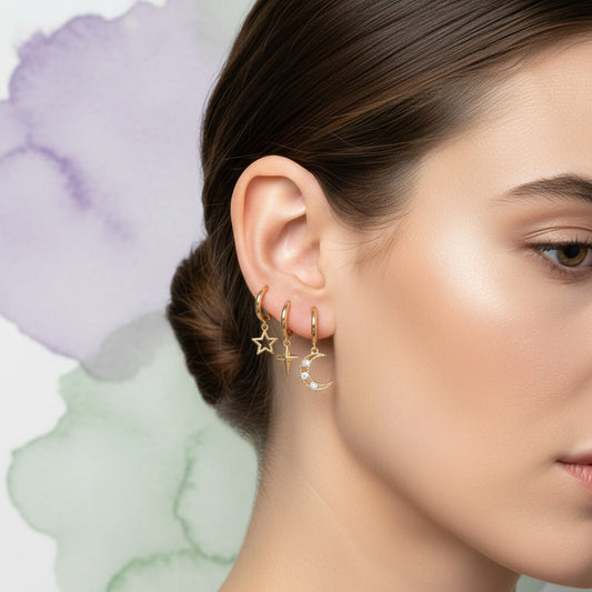 Aramat Jewels set of 6 gold-plated sterling silver hoop earrings with charms: star, cross, star with cubic zirconia, crescent moon with cubic zirconia, sun, and a clear cubic zirconia.