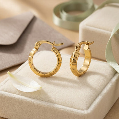 Aramat Jewels small gold hoop earrings with a subtle stripe pattern, 10mm diameter, made of stainless steel.