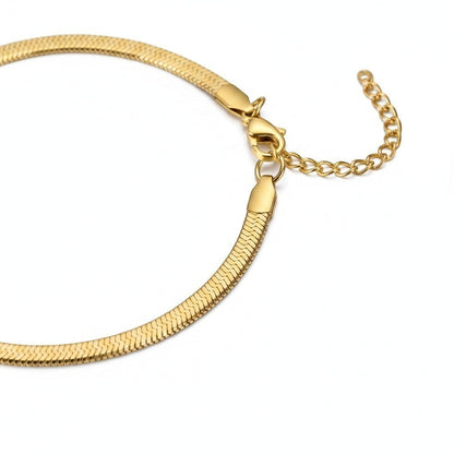 Aramat Jewels goudkleurig stalen enkelbandje met platte visgraad snakechain schakel en verstelbaar verlengkettinkje.