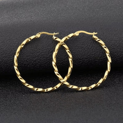 Aramat Jewels Goudkleurige RVS swirl hoepeloorbellen 30 mm met scharniersluiting.