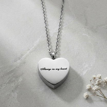 Aramat Jewels silver-tone stainless steel heart-shaped cremation pendant necklace with "Always in my heart" engraving.