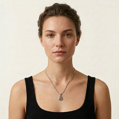 Aramat Jewels silver teardrop cremation pendant with colorful Murano glass floral inlay on a model.