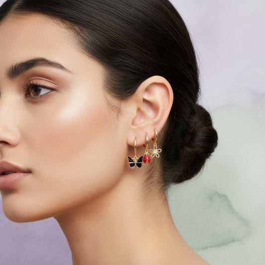 Aramat Jewels set of 6 gold-plated 925 silver hoop earrings with nature-themed charms: green marquise gem, white flower, black butterfly, bee, ladybug, and pink flower.