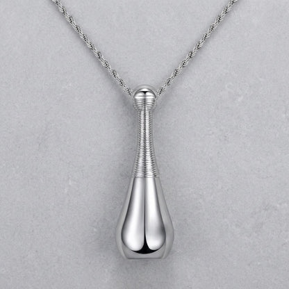 Aramat Jewels silver-colored 316L steel cone-shaped cremation pendant with a rope chain. The pendant has a ribbed texture on the neck and a smooth, teardrop-shaped base.