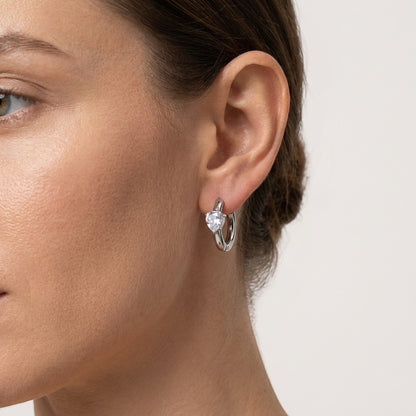 Aramat Jewels silver-tone hoop earrings with a clear heart-shaped cubic zirconia.