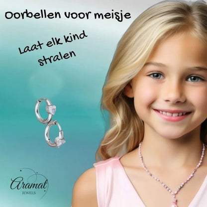 Aramat Jewels silver-tone hoop earrings with heart-shaped cubic zirconia, worn by a smiling young girl.