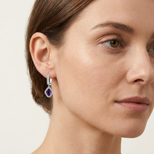 Aramat Jewels silver hoop earrings with a floral charm featuring a purple oval zirconia stone surrounded by small clear stones.