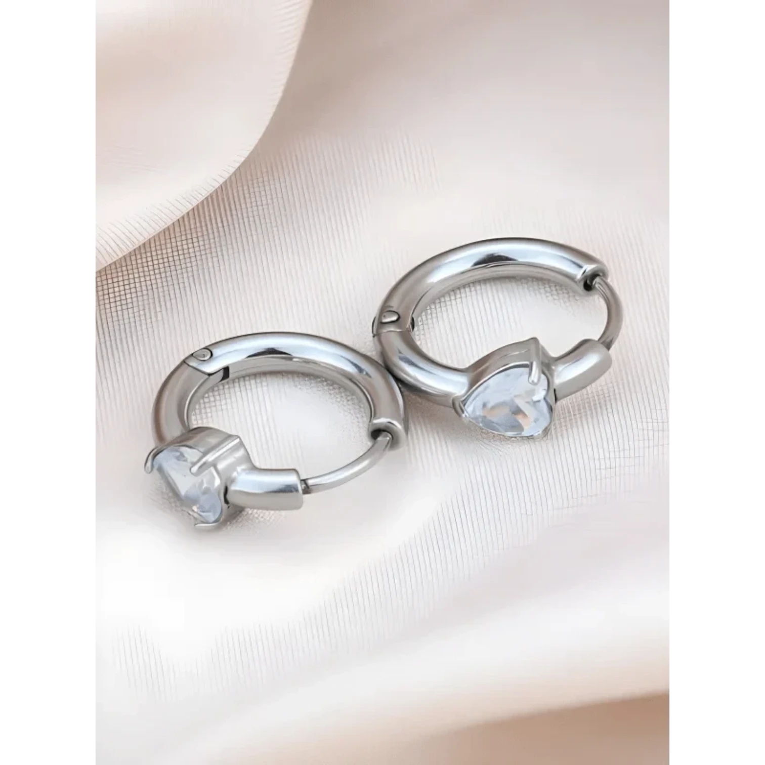 Aramat Jewels silver-tone stainless steel hoop earrings with clear heart-shaped cubic zirconia.
