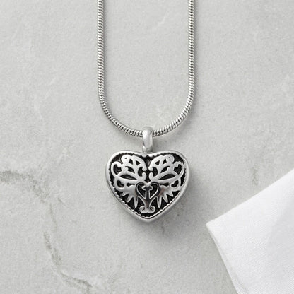 Aramat Jewels silver-tone steel heart-shaped cremation pendant with black enamel inlay and ornate filigree design.