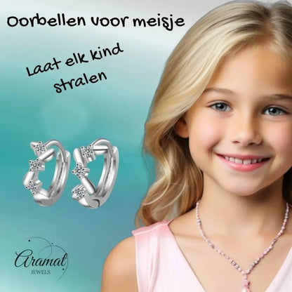 Aramat Jewels silver hoop earrings with clear cubic zirconia and zigzag pattern, 12mm. A smiling young girl with blonde hair wears them.