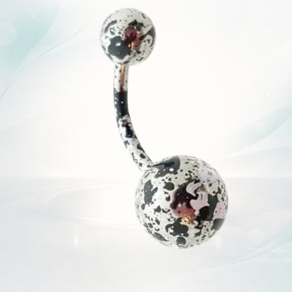 Aramat Jewels steel belly button piercing with a curved bar and speckled black and white design on the balls.