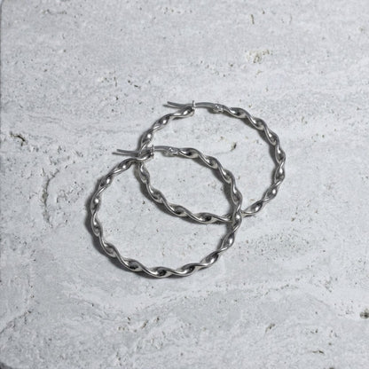 Aramat Jewels silver-tone twisted hoop earrings, 40mm diameter, high-gloss finish, made of stainless steel.