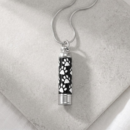 Aramat Jewels zilverkleurige stalen ashanger buis met zwarte en witte dierenpootjes, voor een dierbare herinnering.