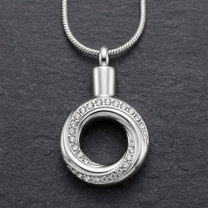 Aramat Jewels zilverkleurige RVS ashanger in open cirkelvorm, versierd met kristallen. 30x20mm.