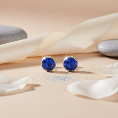 Aramat Jewels zilverkleurige oorstekers met donkerblauwe kristallen van 7mm, gemaakt van roestvrij staal.