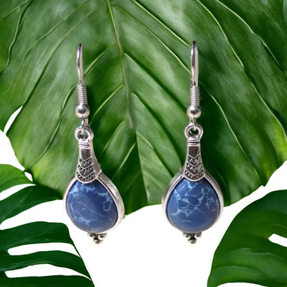 Een paar oorbellen met een blauwe steen