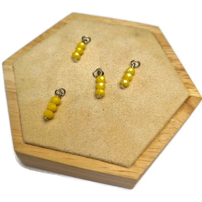 Een paar oorbellen van geel glas op een houten plank