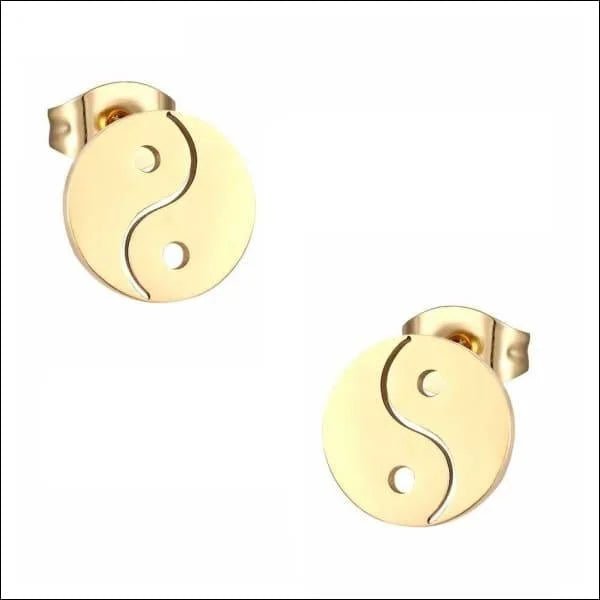 Een paar gouden oorbellen met een yin-symbool