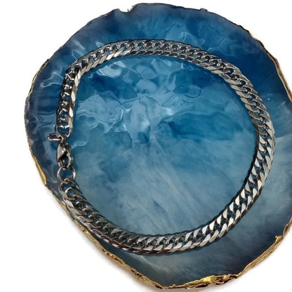 Een close-up van een zilveren armband op een blauwe agaat