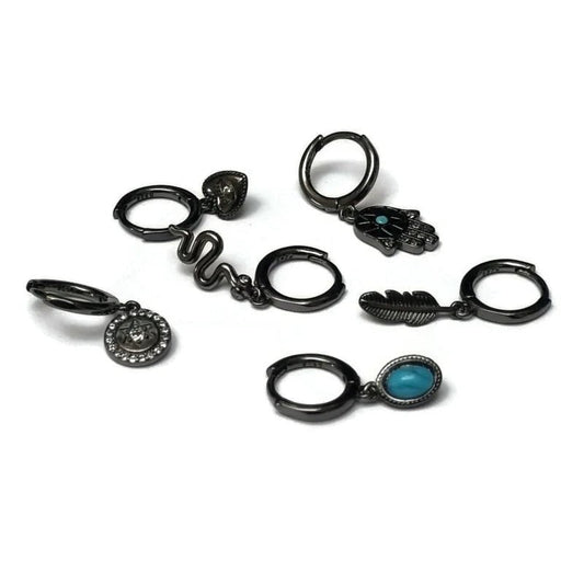 Een set van vijf zwart metalen ringen met turquoise steenaccenten