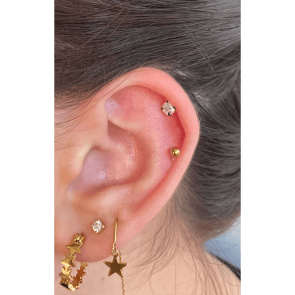 Een vrouw met een gouden ster oorpiercing