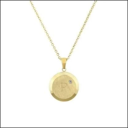 Een gouden schijfvormige hanger met een diamant erop