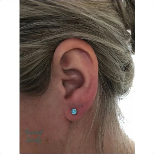 Een vrouw met een blauwe oorpiercing