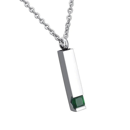 Een rechthoekige hanger met een groene steen aan een ketting