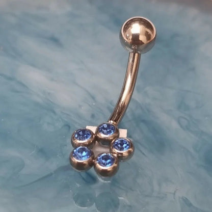 Er is een glanzende blauwe buikring met blauwe stenen