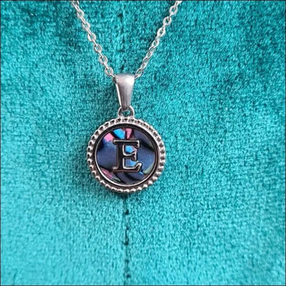 Een zilveren halsketting met een blauwe en paarse glazen hanger