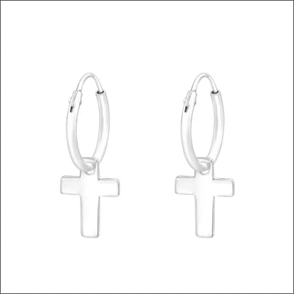 Een paar zilveren oorbellen met een kruis op de voorkant