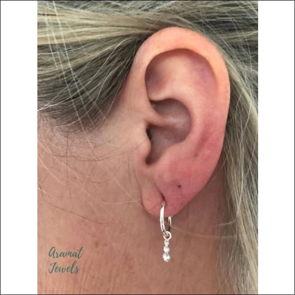 Het oor van een vrouw met een kleine diamanten oorbel